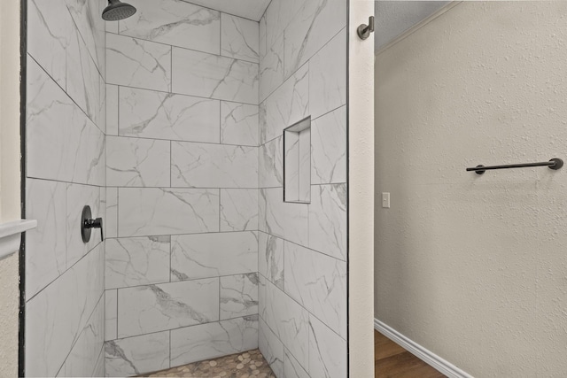 bathroom with hardwood / wood-style flooring and a tile shower