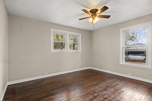 empty room with ceiling fan and dark hardwood / wood-style flooring