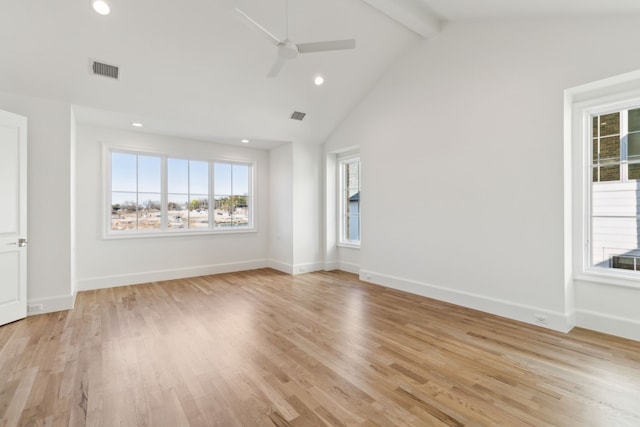 spare room featuring light wood-type flooring, a wealth of natural light, beam ceiling, and high vaulted ceiling