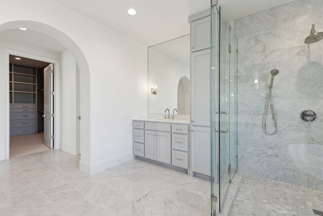 bathroom with a shower with door and vanity