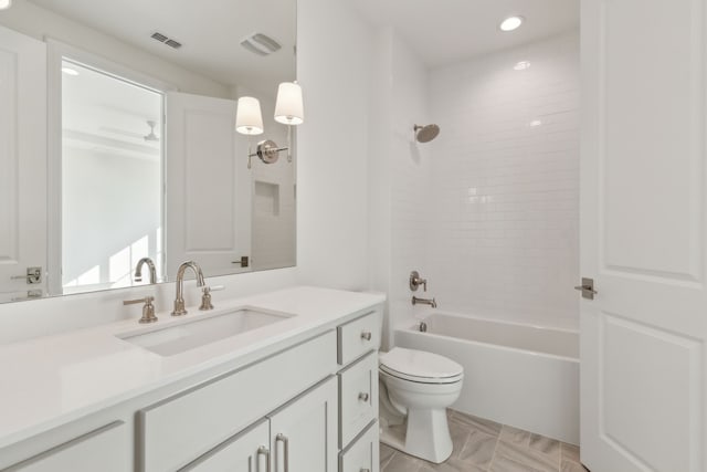 full bathroom featuring tiled shower / bath combo, vanity, and toilet