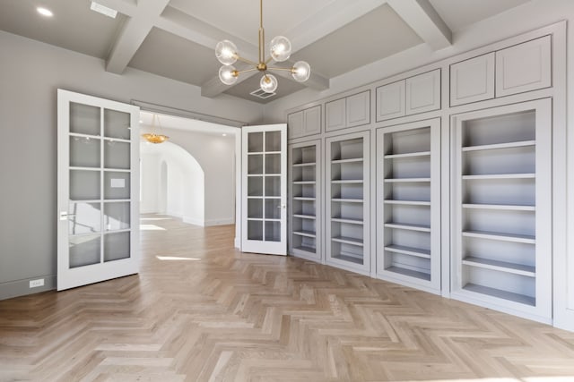 walk in closet featuring french doors, beam ceiling, and an inviting chandelier