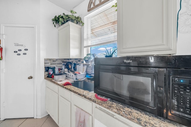 kitchen with backsplash, white cabinets, light tile patterned floors, and light stone countertops