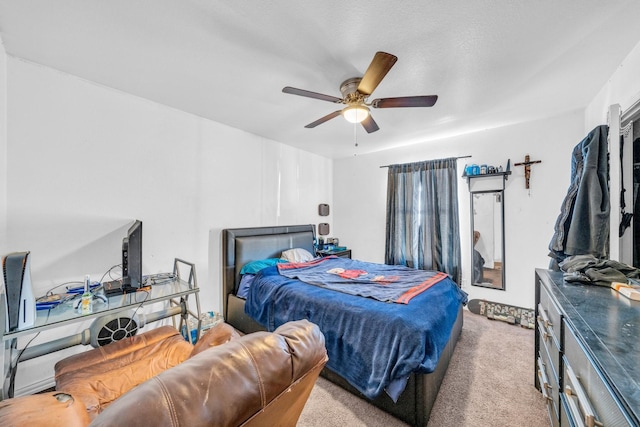 carpeted bedroom featuring ceiling fan and a textured ceiling