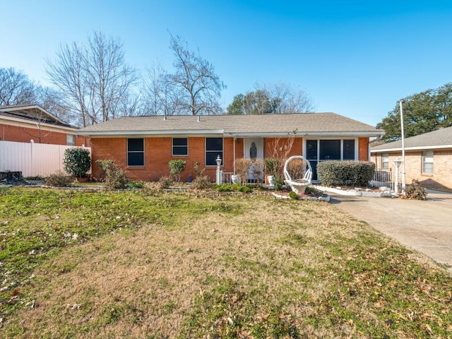 ranch-style home with covered porch and a front lawn