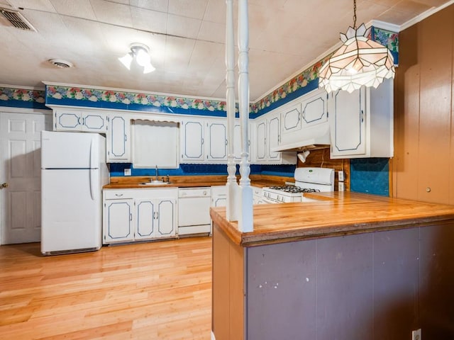 kitchen featuring kitchen peninsula, white appliances, butcher block countertops, and hanging light fixtures