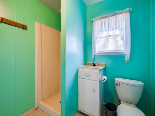 bathroom featuring toilet, a shower, and vanity