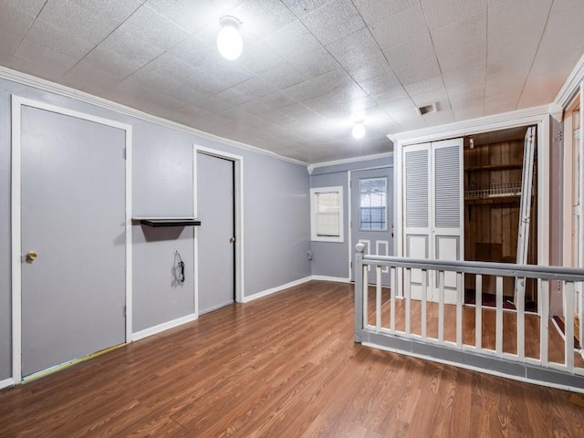 spare room with ornamental molding and wood-type flooring