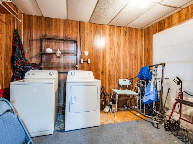 laundry room featuring washing machine and dryer and wooden walls