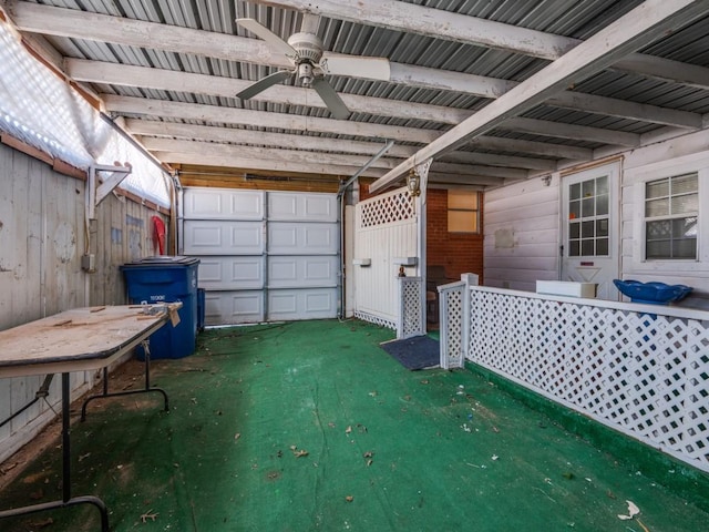 garage featuring ceiling fan and wooden walls