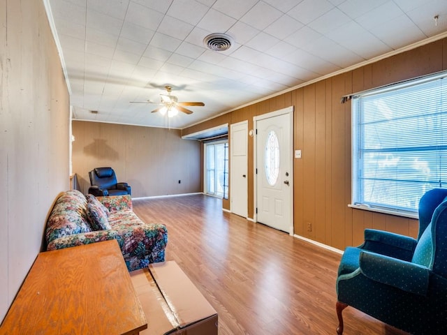 living room with crown molding, hardwood / wood-style floors, and ceiling fan