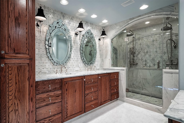 bathroom with vanity, a shower with shower door, and tasteful backsplash