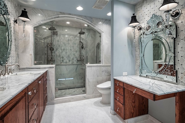 bathroom featuring a shower with door, toilet, and vanity