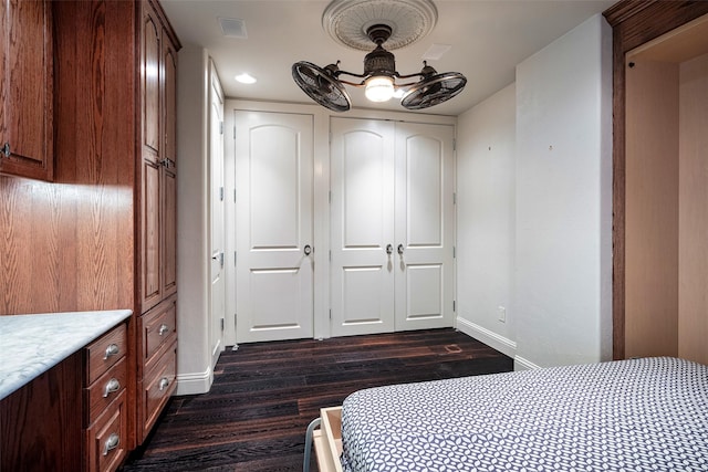 unfurnished bedroom with ceiling fan and dark wood-type flooring