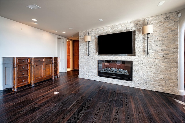 unfurnished living room with a stone fireplace and dark hardwood / wood-style flooring