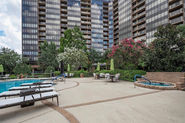 surrounding community featuring a pool with hot tub and a patio