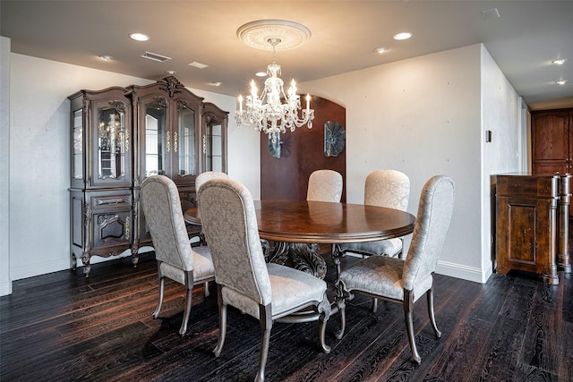 dining space with an inviting chandelier and dark hardwood / wood-style floors