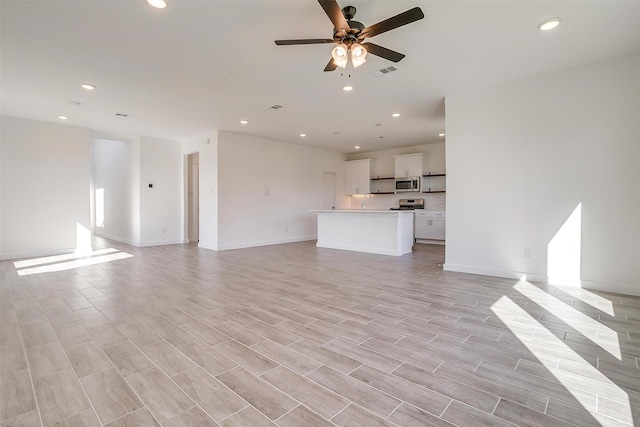 unfurnished living room with ceiling fan