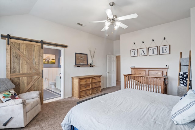 bedroom with carpet, lofted ceiling, connected bathroom, ceiling fan, and a barn door