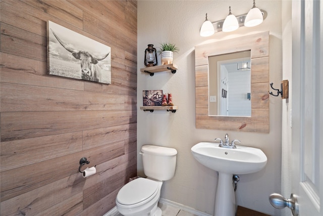 bathroom with toilet and wooden walls