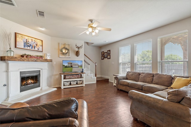 living room featuring dark wood-type flooring and ceiling fan