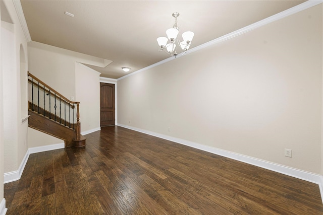 empty room with dark hardwood / wood-style flooring, crown molding, and a chandelier