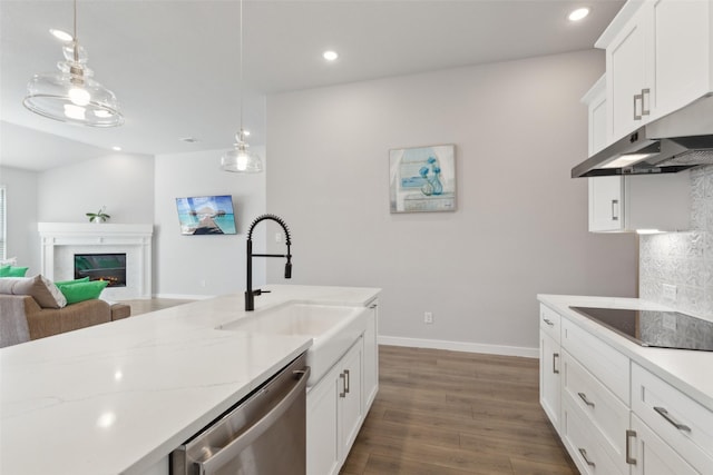 kitchen with a fireplace, dishwasher, sink, white cabinets, and decorative light fixtures