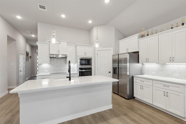 kitchen featuring stainless steel appliances, white cabinetry, pendant lighting, and backsplash