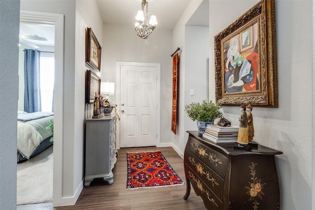 foyer entrance with an inviting chandelier and dark hardwood / wood-style floors