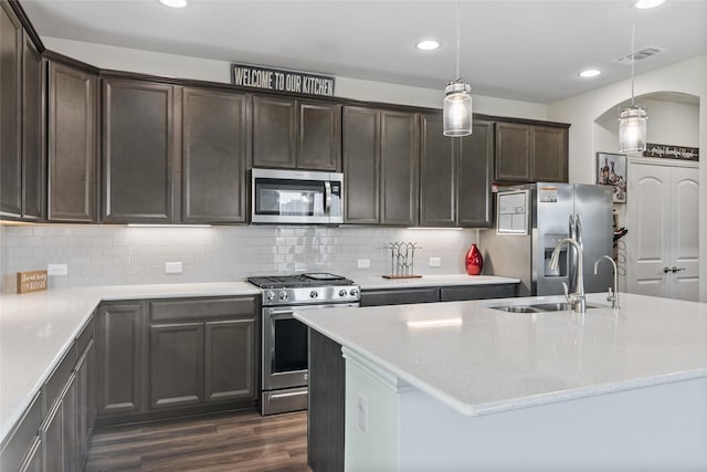 kitchen featuring appliances with stainless steel finishes, sink, decorative backsplash, hanging light fixtures, and dark wood-type flooring