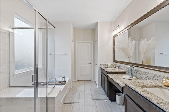 bathroom with vanity and shower with separate bathtub