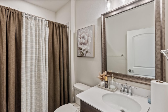 bathroom with walk in shower, vanity, and toilet