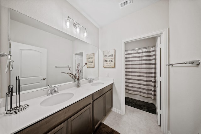 bathroom featuring walk in shower, vanity, and tile patterned flooring