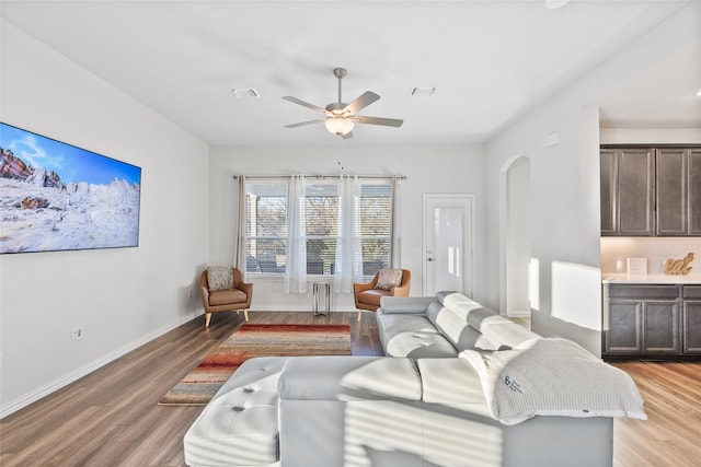 living room with radiator heating unit, light hardwood / wood-style flooring, and ceiling fan