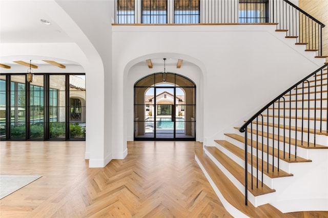 entryway featuring parquet flooring and a towering ceiling