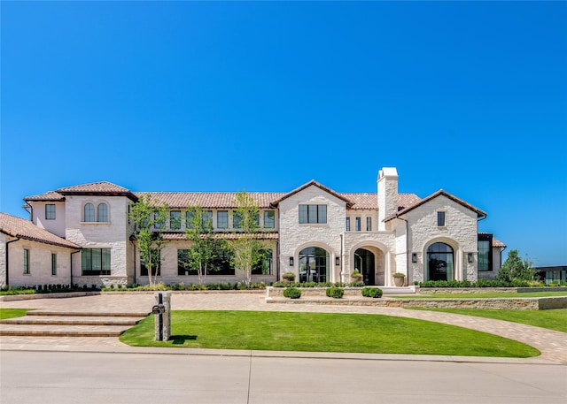 mediterranean / spanish-style home with a front yard