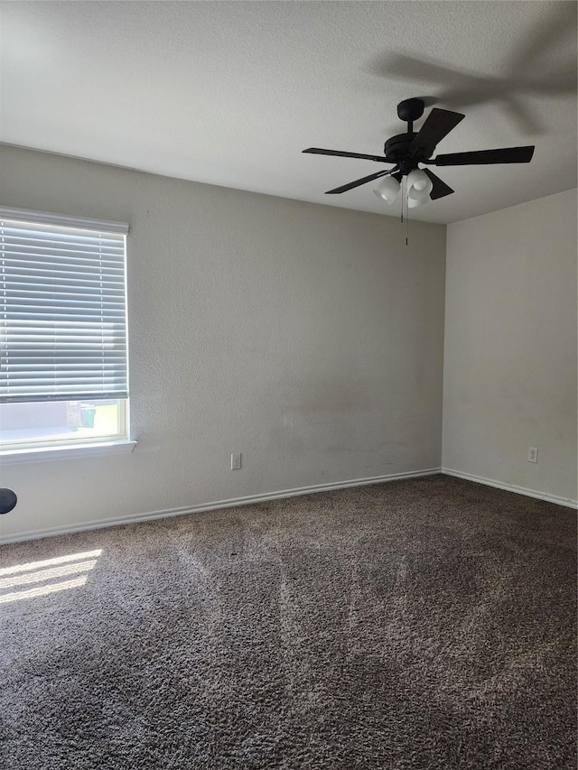 carpeted empty room with ceiling fan and a textured ceiling