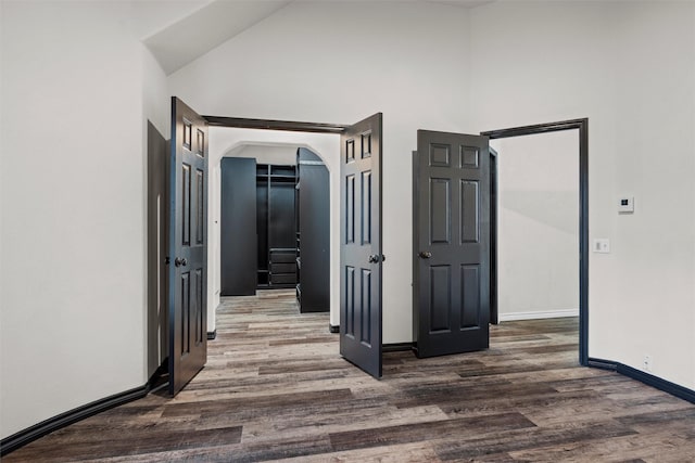 corridor featuring dark hardwood / wood-style floors and high vaulted ceiling