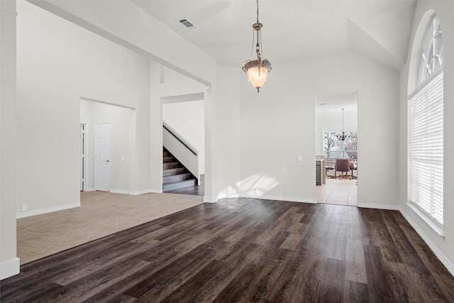 interior space featuring a healthy amount of sunlight, dark hardwood / wood-style floors, and a notable chandelier