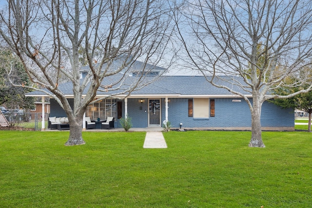 view of front facade with roof with shingles, fence, a patio area, an outdoor living space, and a front yard