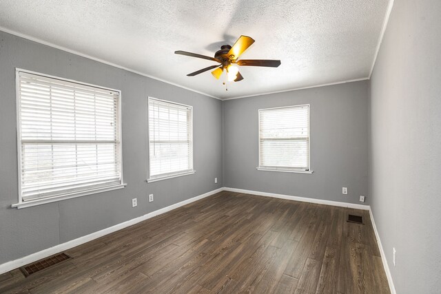 spare room featuring dark hardwood / wood-style flooring, crown molding, plenty of natural light, and ceiling fan