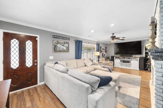 living room with crown molding, ceiling fan, and hardwood / wood-style flooring