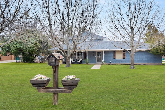 view of front of property with an outdoor hangout area, a front lawn, and brick siding