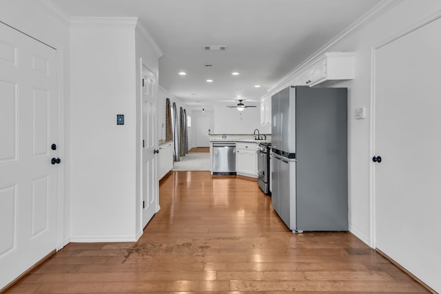 kitchen featuring white cabinetry, crown molding, and appliances with stainless steel finishes