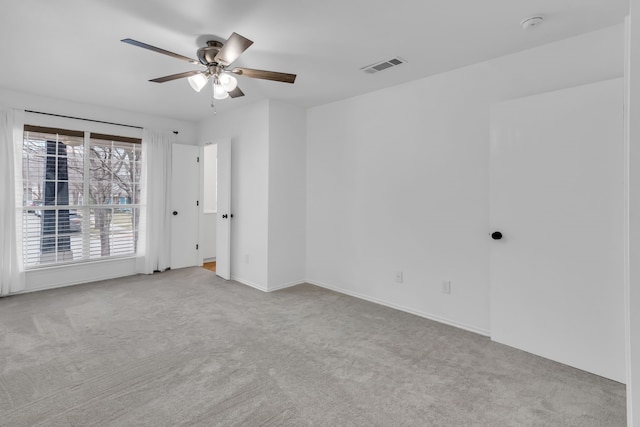 spare room featuring light carpet and ceiling fan