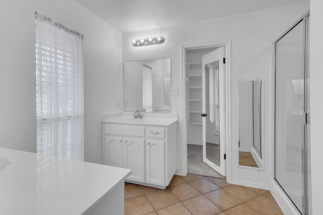 bathroom with tile patterned flooring, an enclosed shower, and vanity