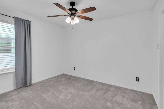 spare room with ceiling fan and light carpet