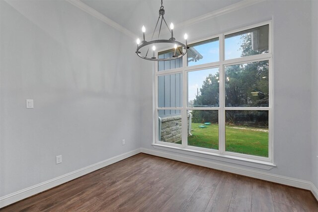 unfurnished dining area with wood-type flooring, a notable chandelier, and ornamental molding