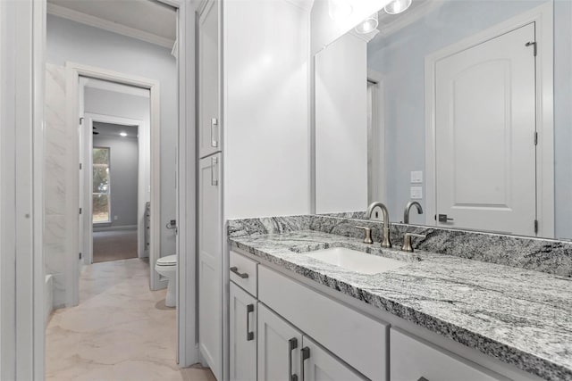 bathroom featuring toilet, vanity, and crown molding