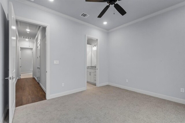 unfurnished bedroom featuring crown molding, light colored carpet, ceiling fan, and ensuite bathroom